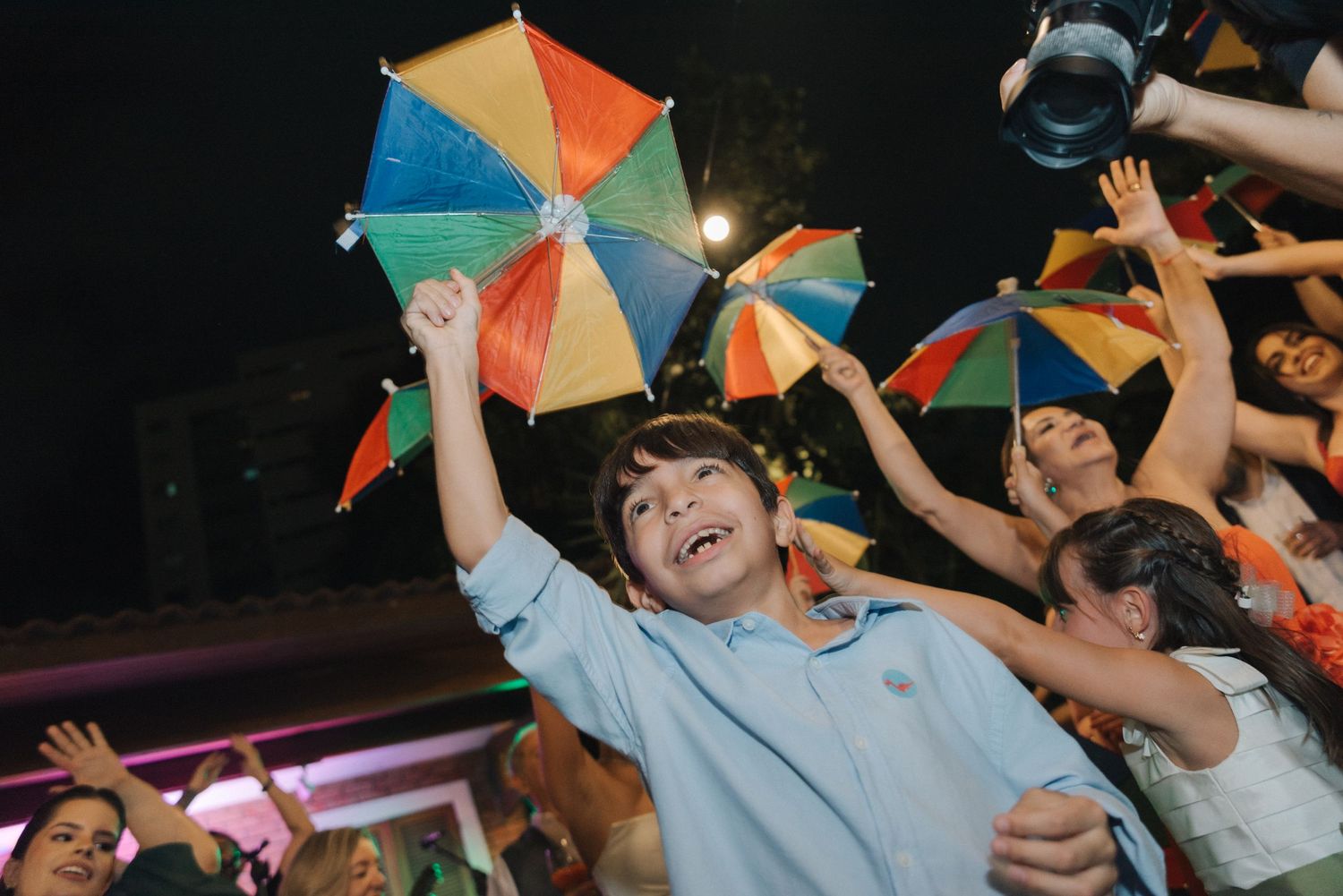 Guests celebrate with colorful umbrellas on a lively dance floor.