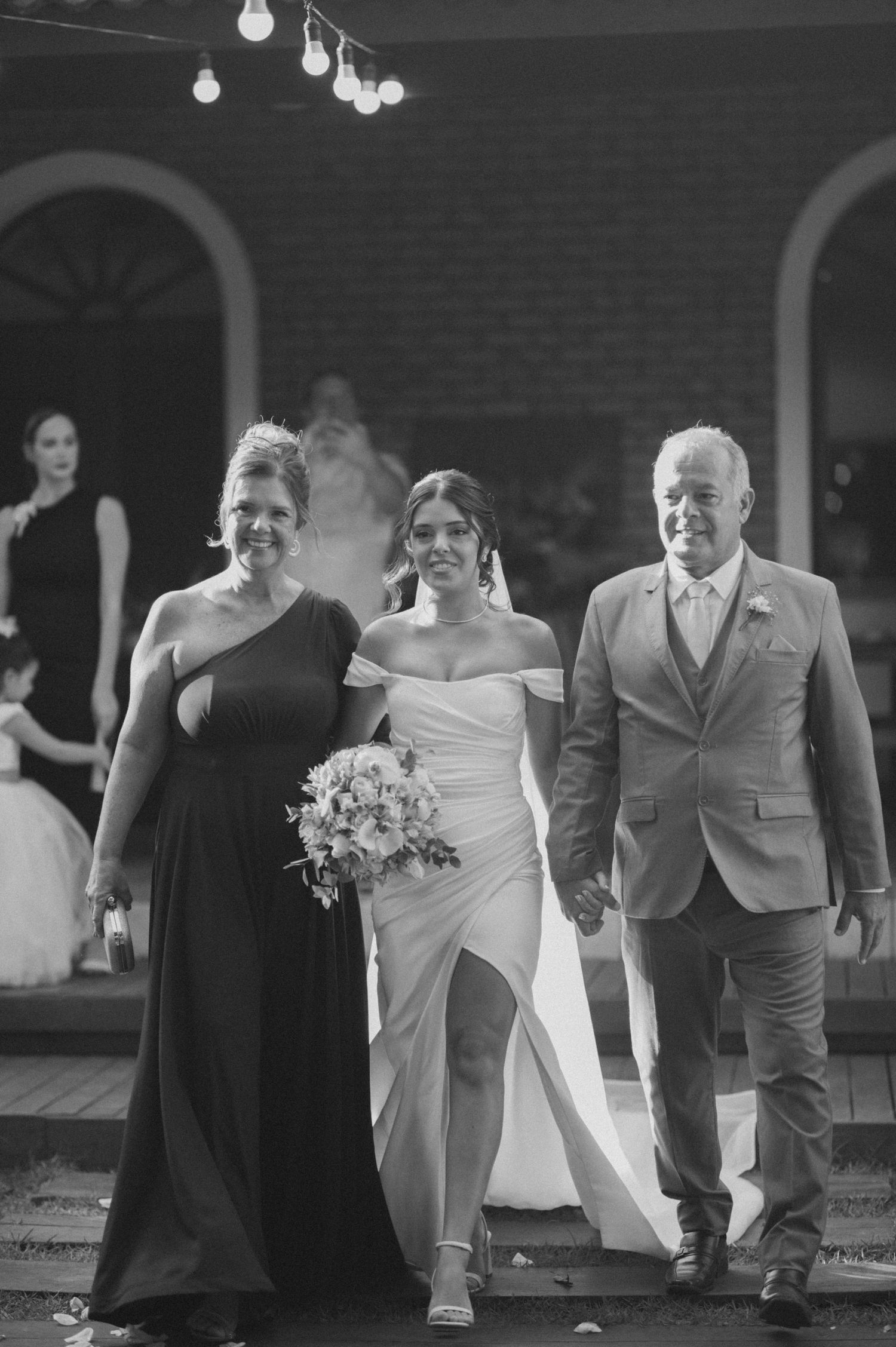 Wedding party members walking down brick-lined steps during evening ceremony.
