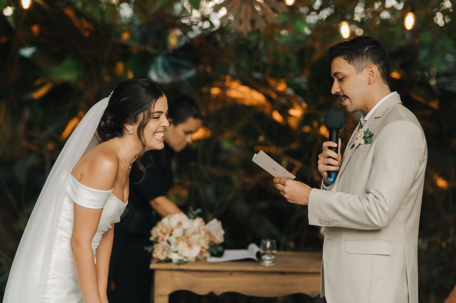 An emotional moment during wedding vows as the bride laughs heartily at the altar.