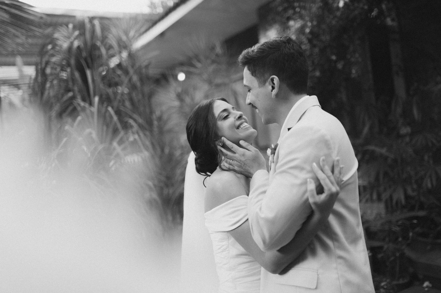Black and white portrait of a loving moment between newlyweds.