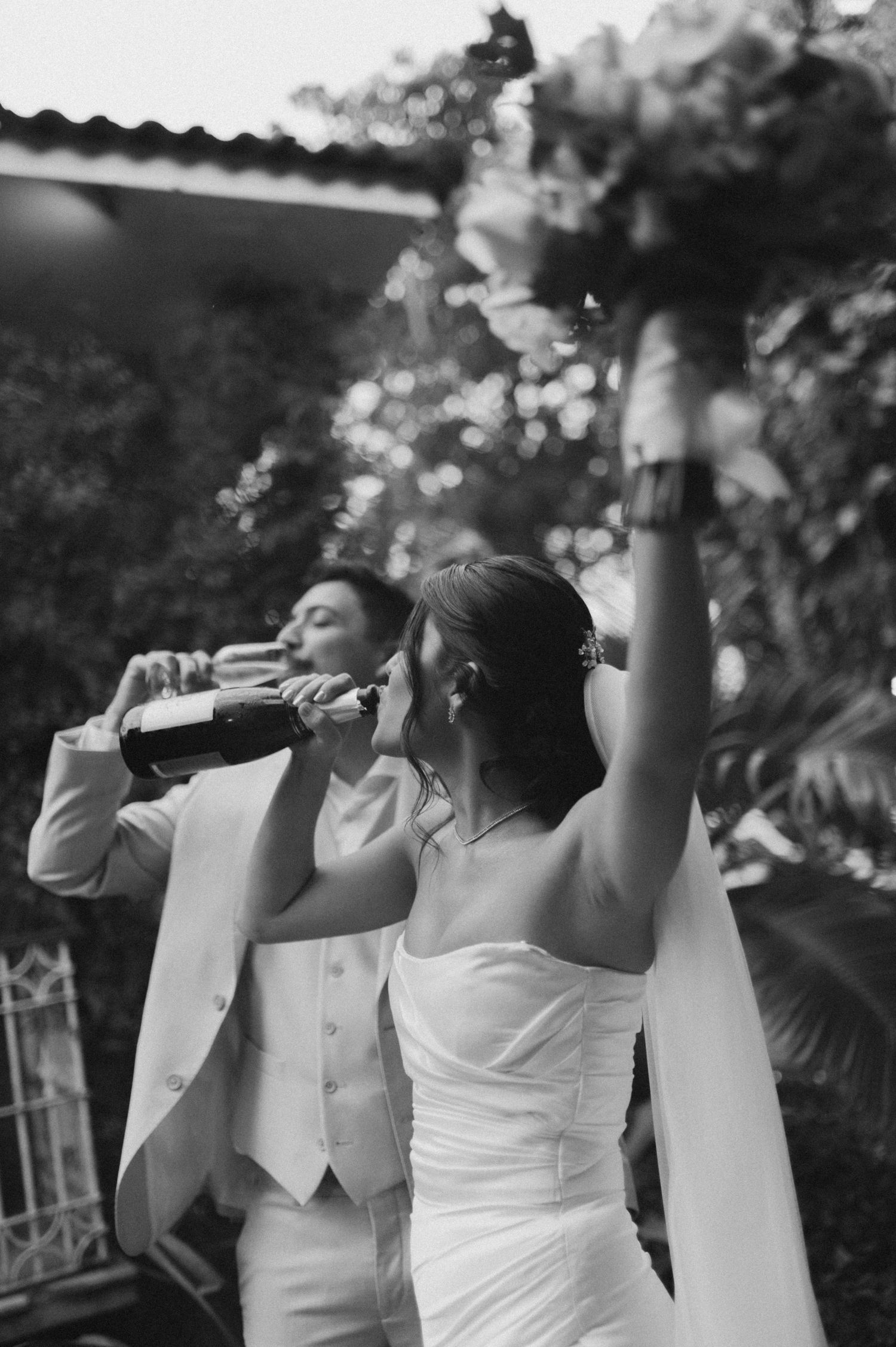 Black and white photo of a couple toasting and celebrating during their wedding reception.