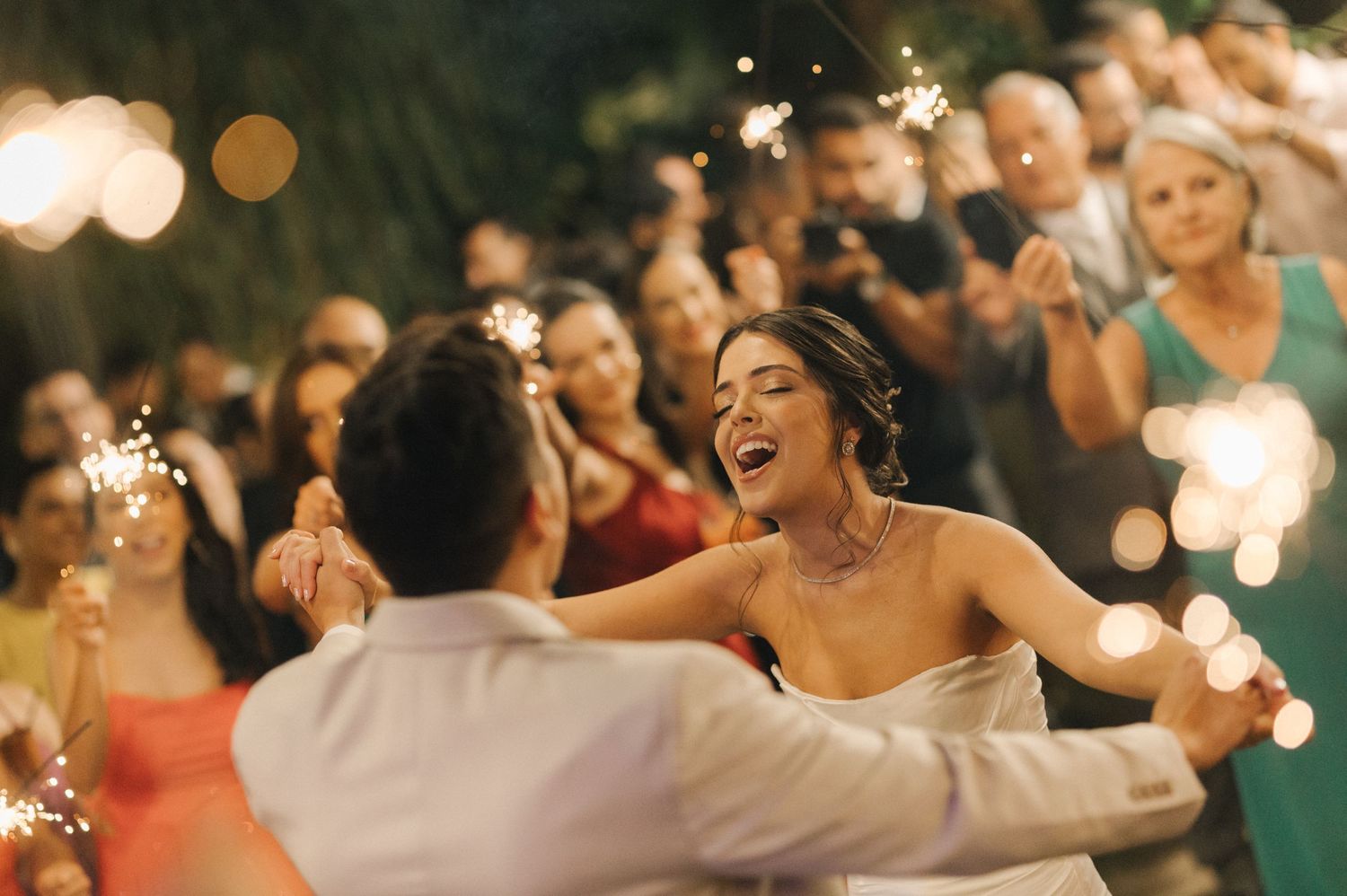 A magical dance moment at a wedding with sparklers illuminating the scene.