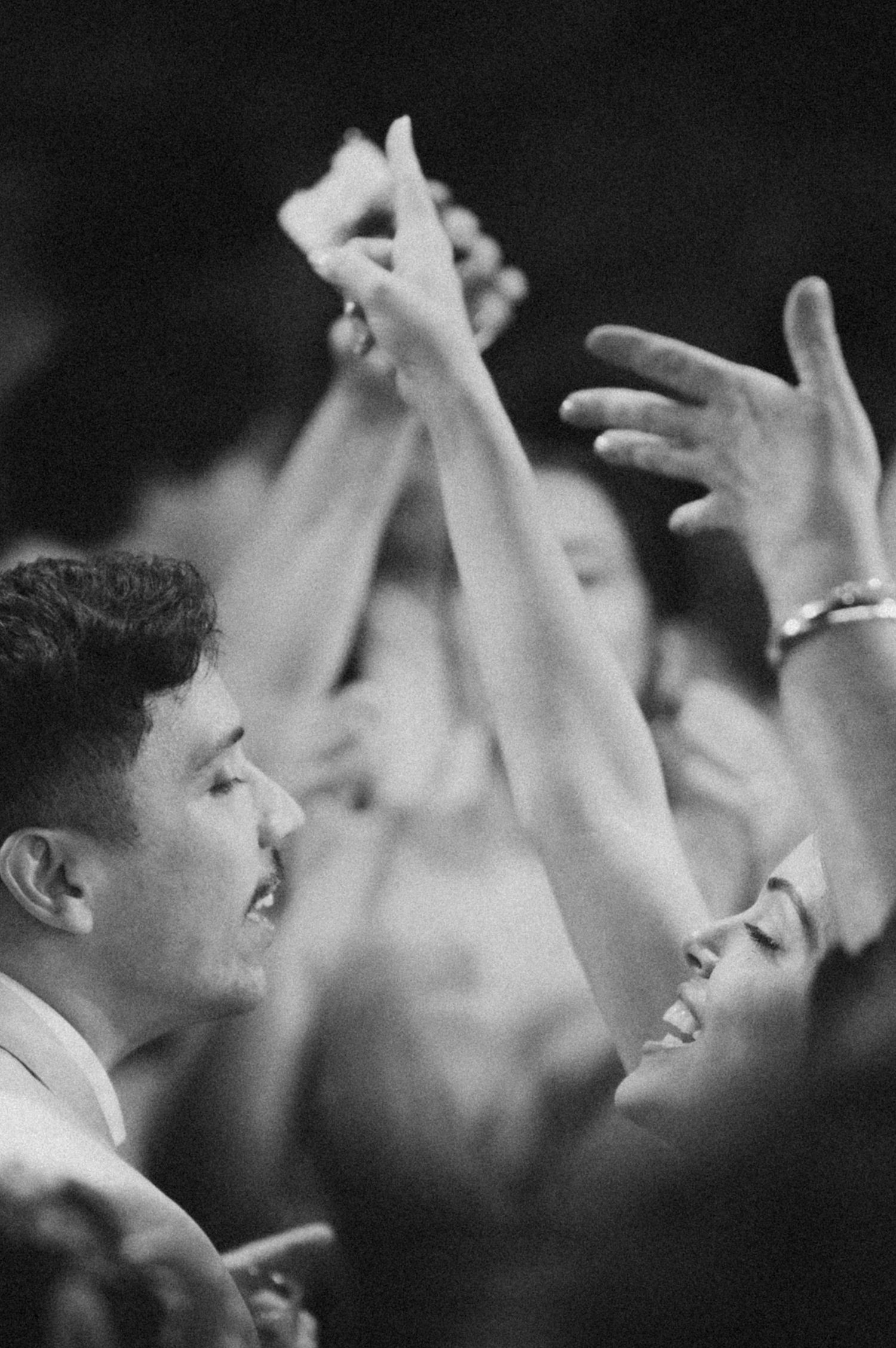 A black and white capture of a celebratory dance moment at a wedding reception.