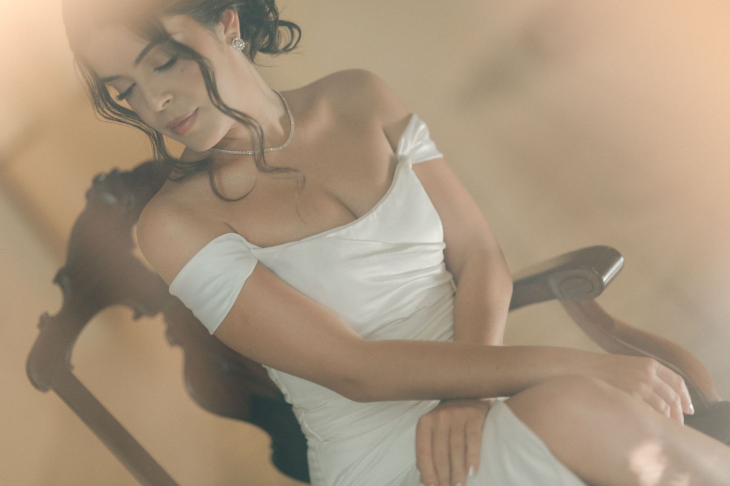 A dreamy boudoir photo shoot with soft lighting and a white dress.