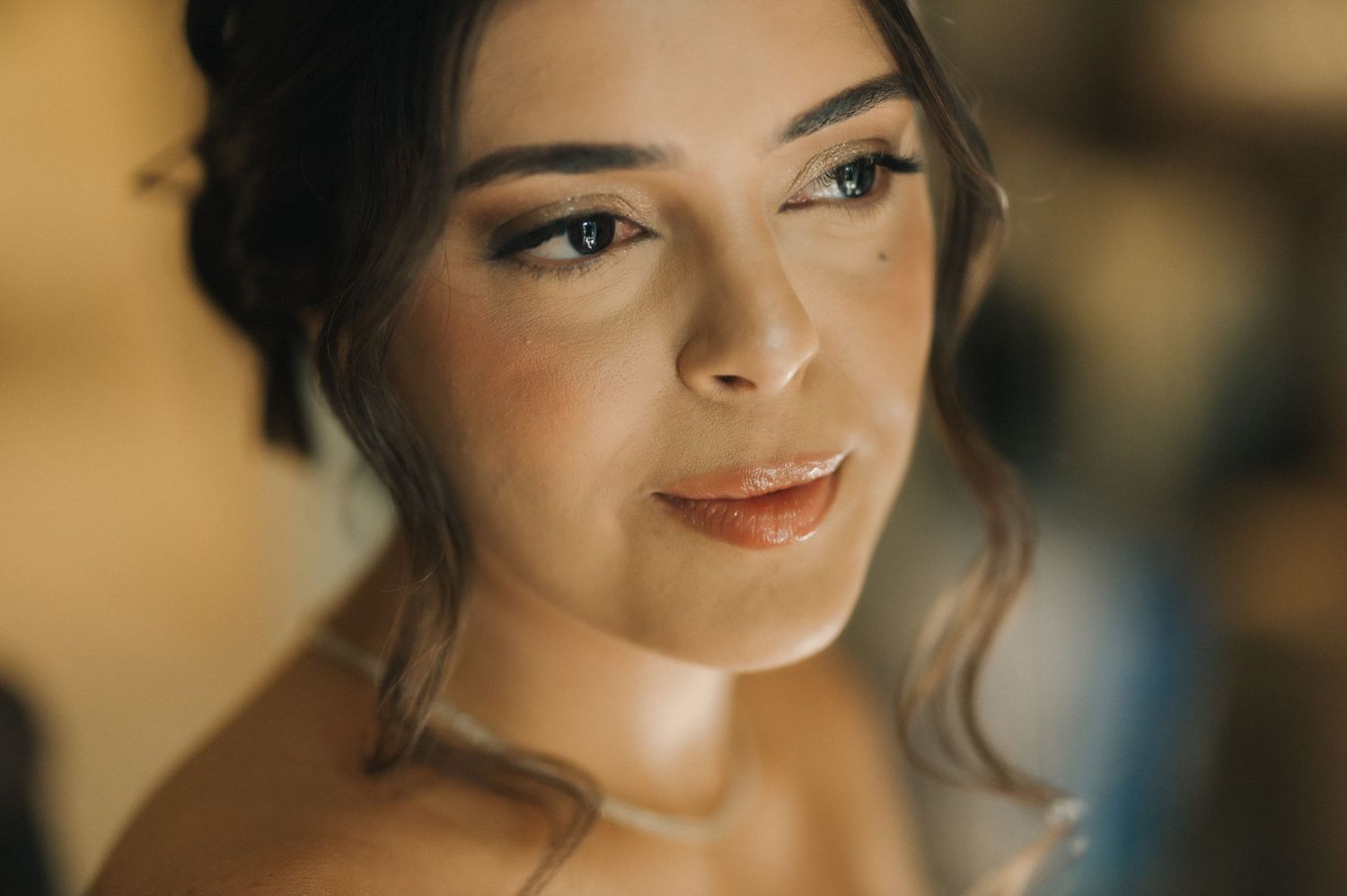 Close-up portrait with warm lighting and delicate makeup.