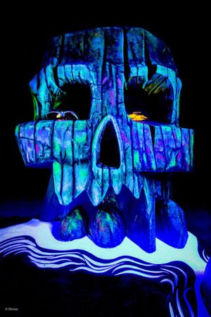 Illuminated ice sculptures glow with vibrant blue and purple lights against a dark background in an artistic winter display.