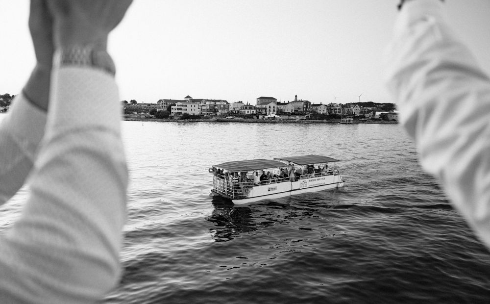 Summer wedding rehearsal dinner on a boat in Gloucester, MA, with guests celebrating, laughing, and enjoying the scenic views.