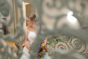 Artistic close-up of wedding details featuring ornate staircase railings and floral bouquets.