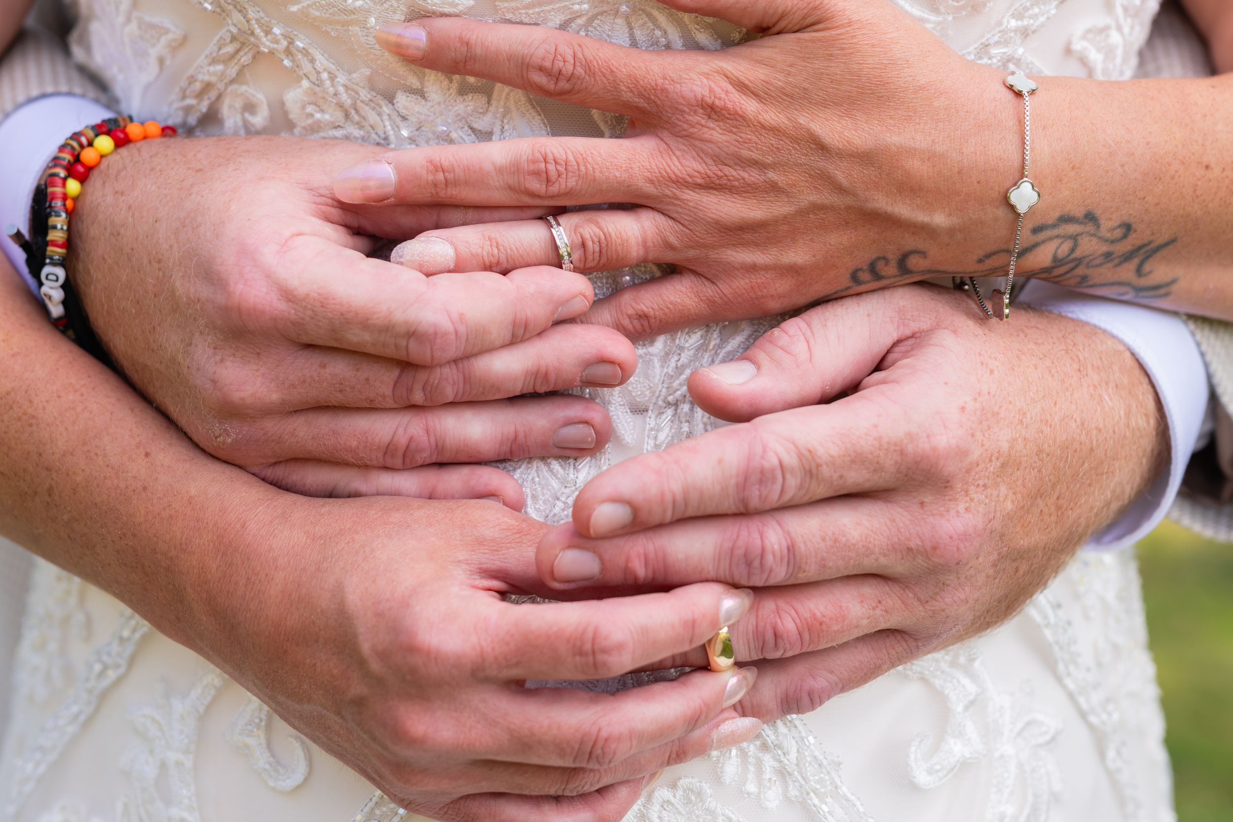Close-up of hands with wedding rings showing intricate details.