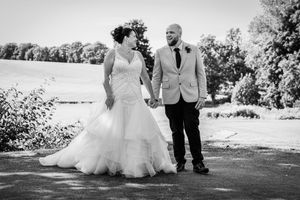 Wedding couple posing together outdoors in a garden setting.