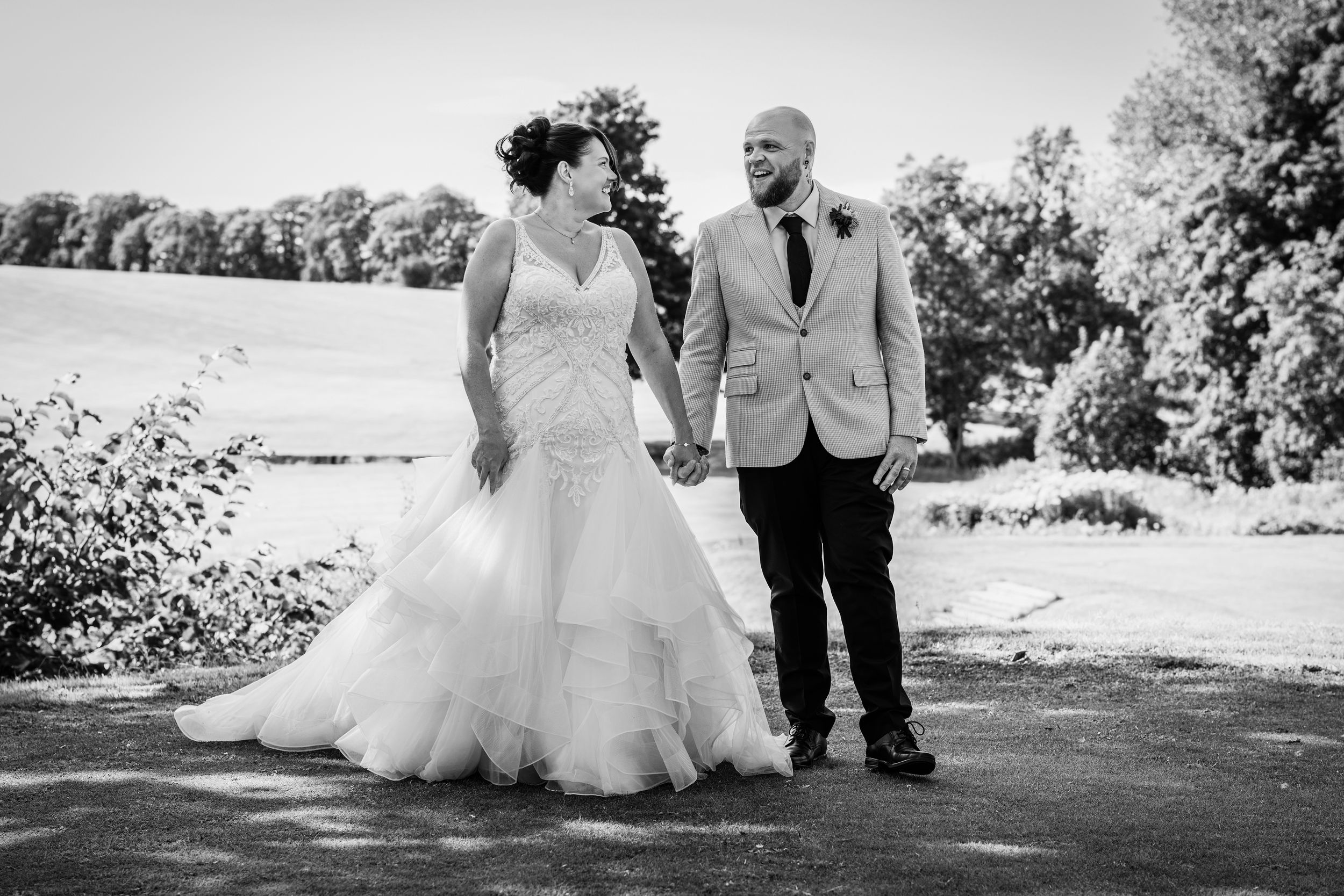 Wedding couple posing together outdoors in a garden setting.
