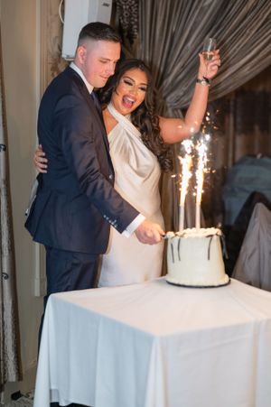 Elegant wedding celebration with sparkler cake and couple sharing a joyous moment.