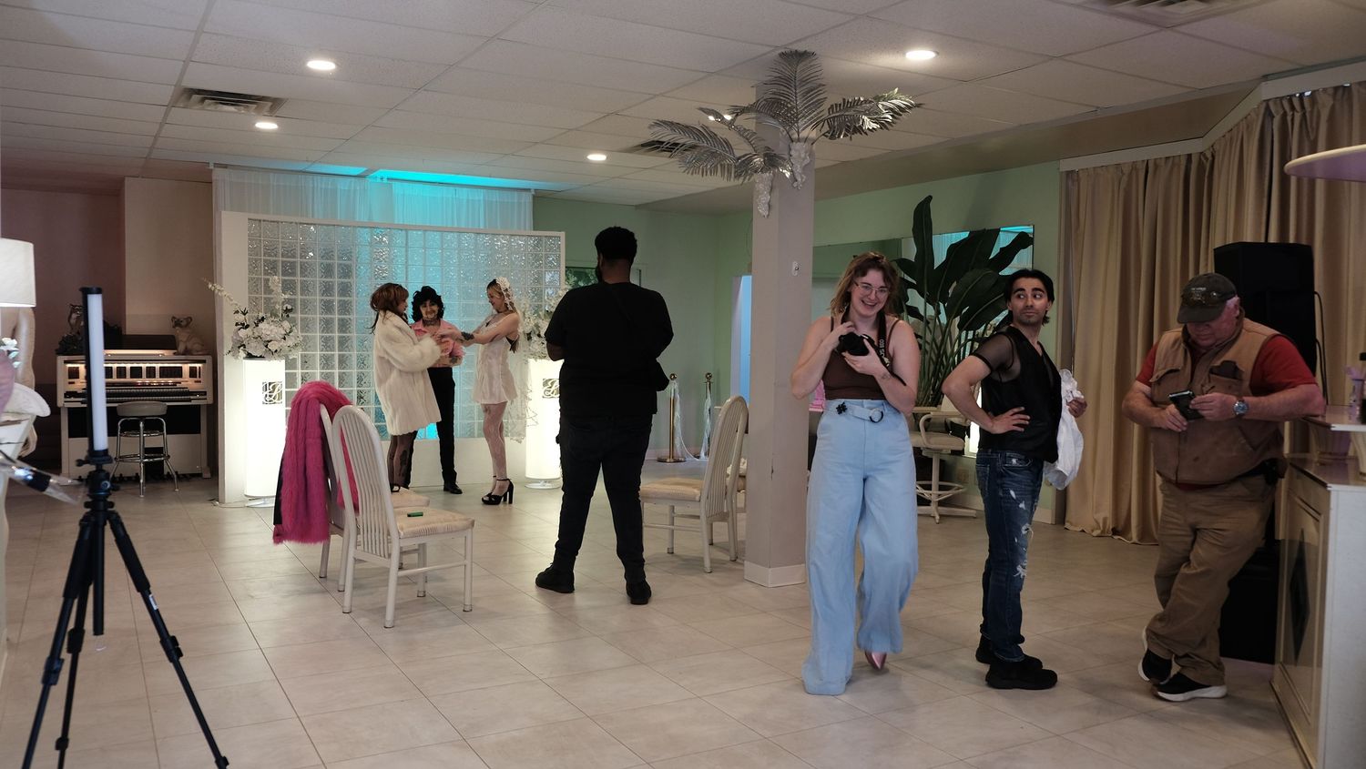 Group of colorful women's shoes shown from ankle down including bright pink heels and patterned flats on stone floor.