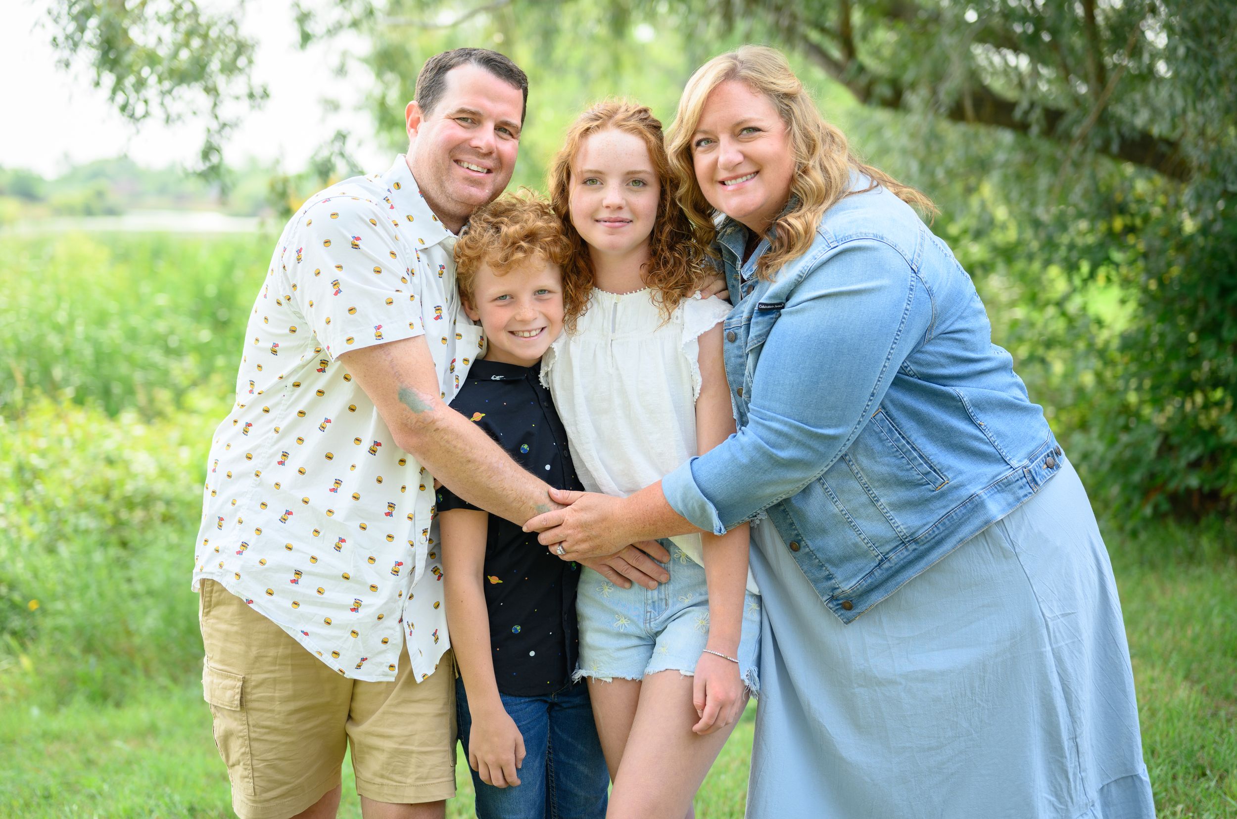 A cheerful group enjoying a sunny day together in a lush green outdoor setting.
