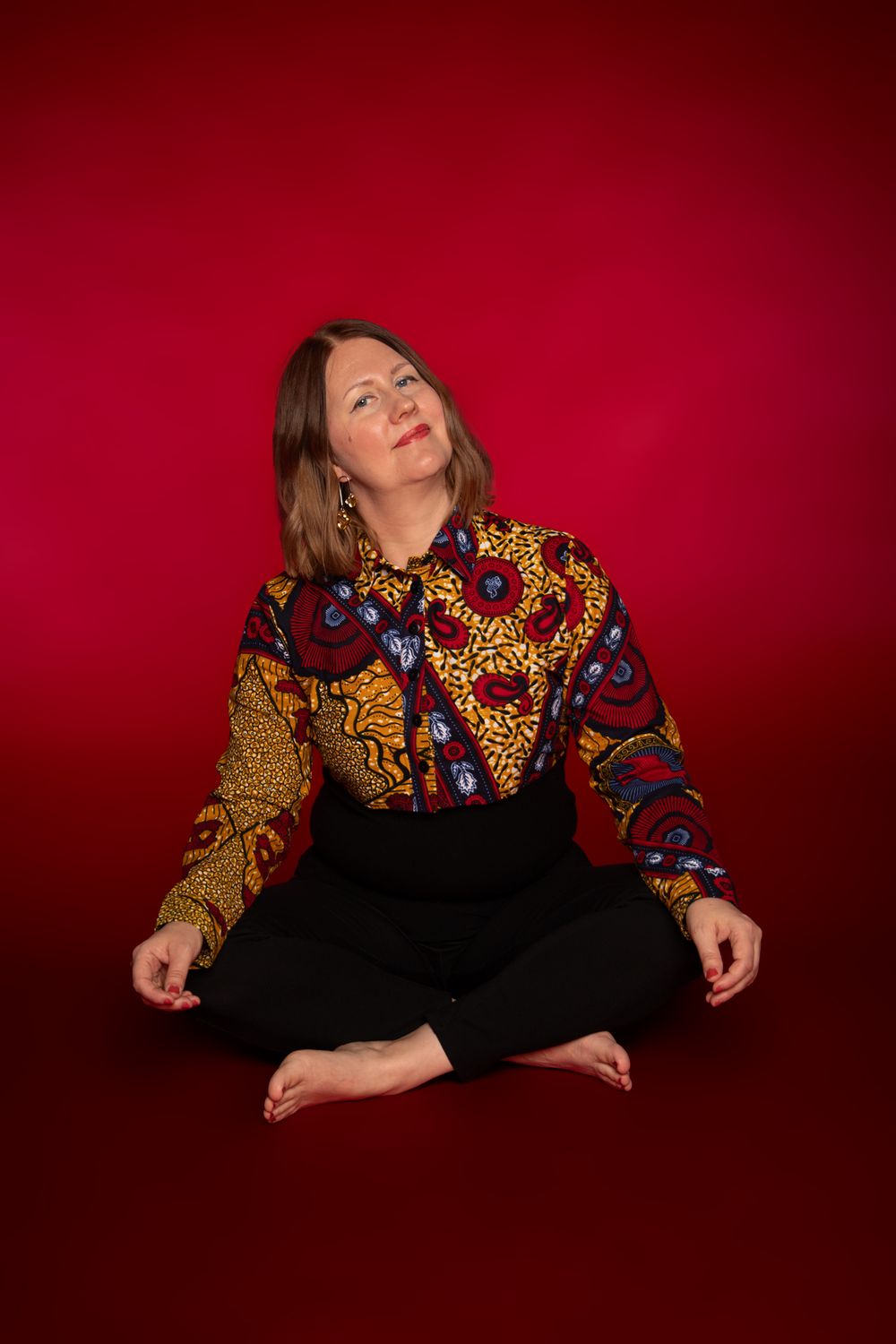 A portrait photo of a woman with red background