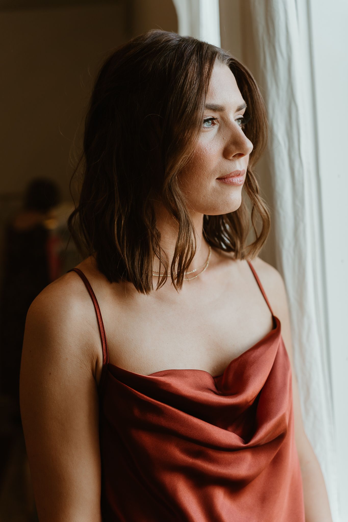 Headshots by window of bridesmaid.