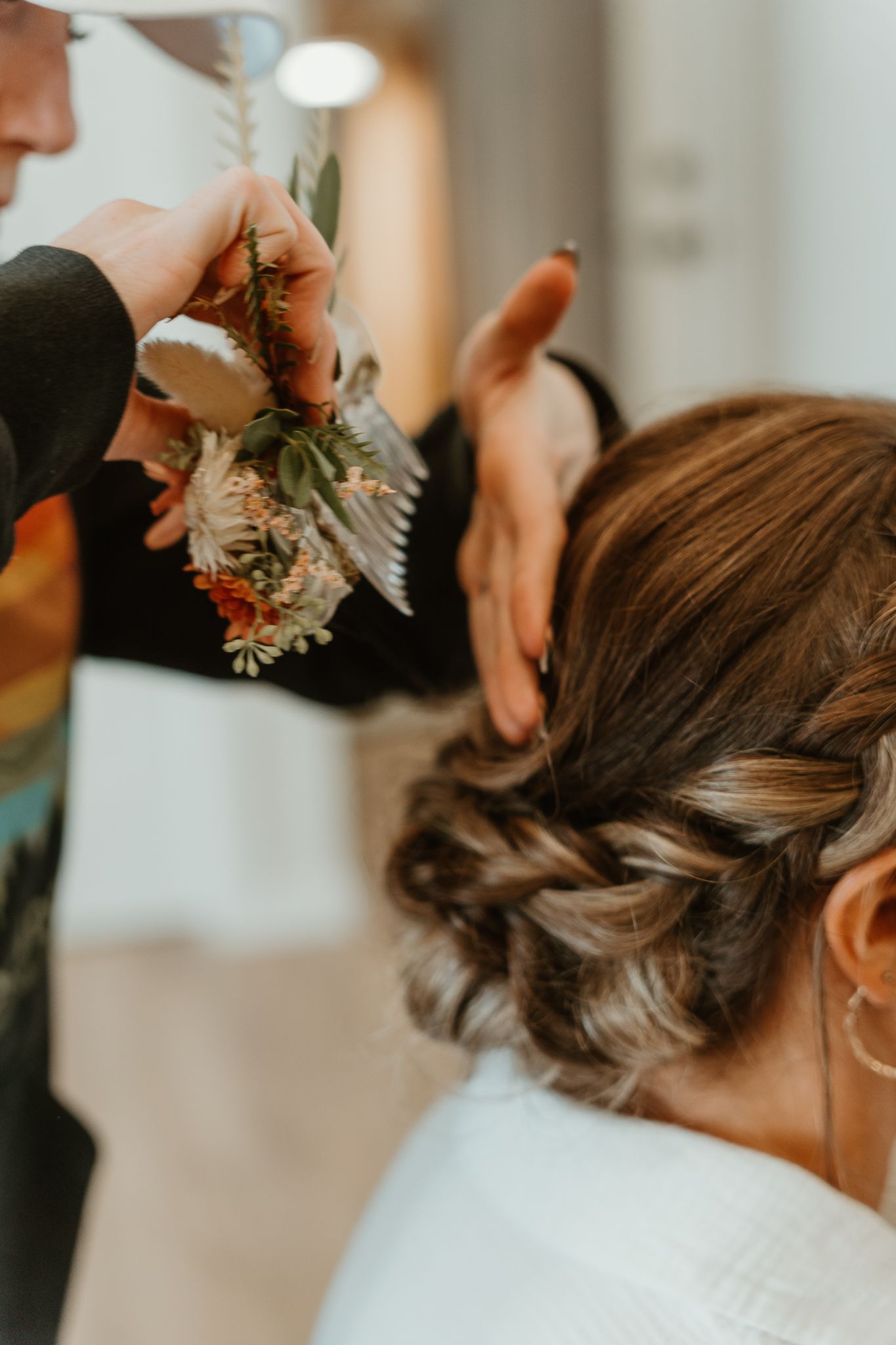 Handmade flower clip being added to the wedding hairstyle.