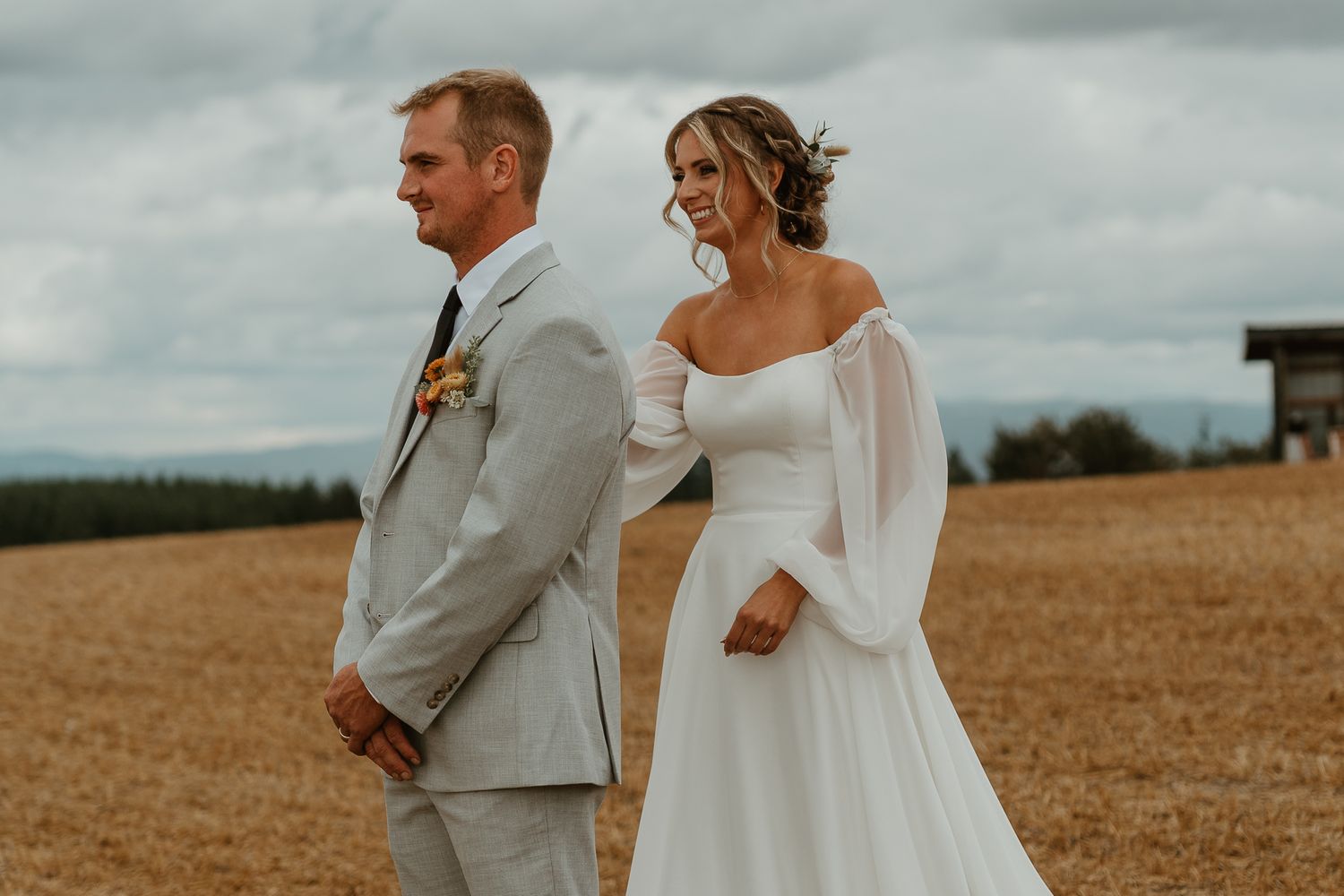 Tapping grooms shoulder to reveal her bridal look.