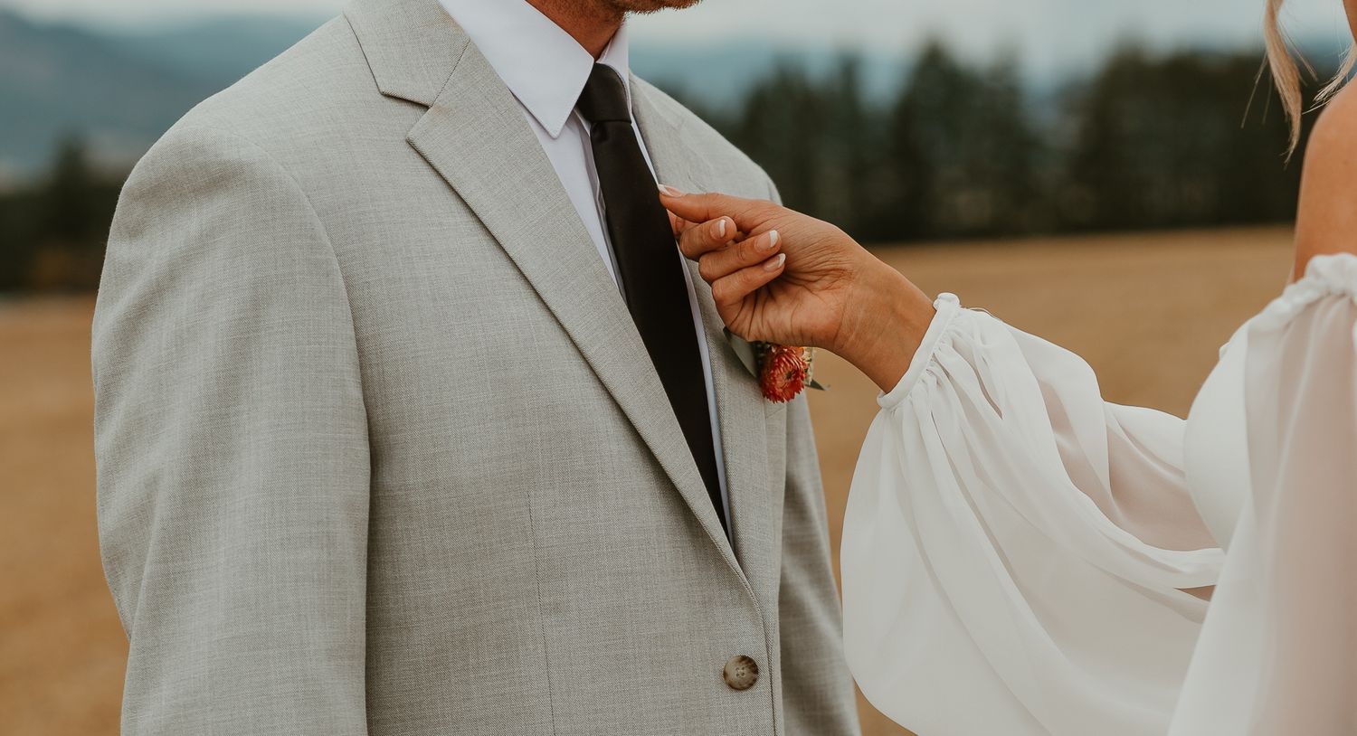 Details of bride fixing grooms tie.