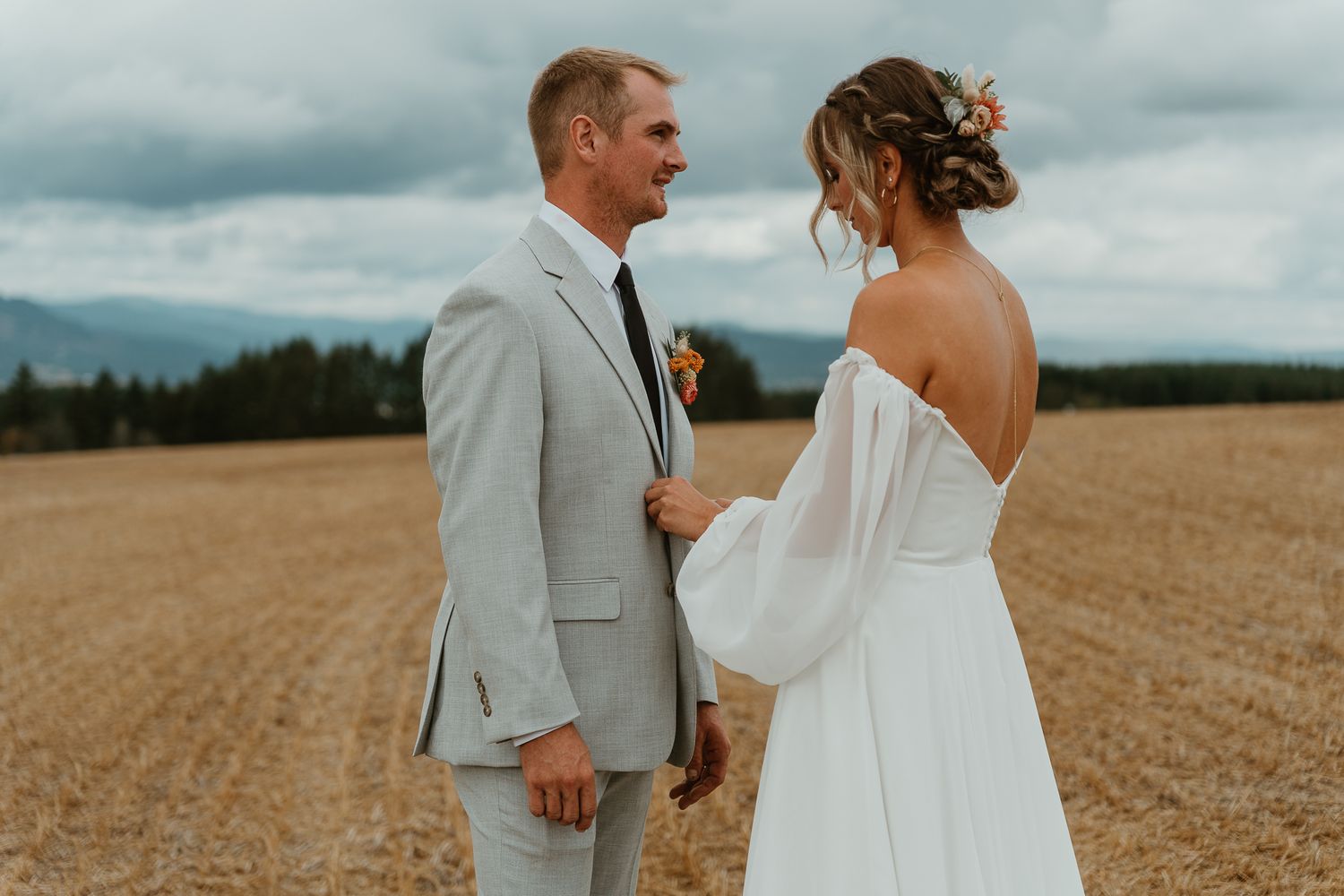 Bride fixing the groom's tie and suit during the first look.