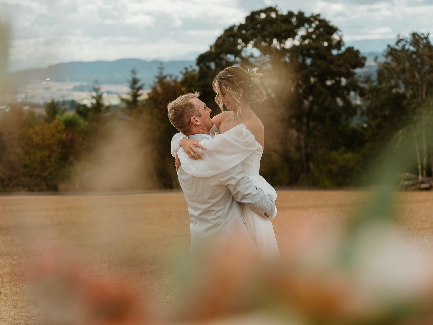 Artistic shot of couple between her wedding flowers.