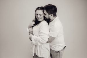 Happy couple sharing a tender moment together in a classic black and white studio portrait.