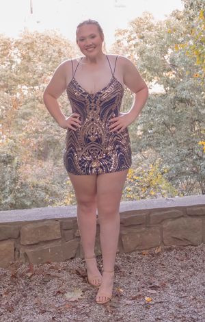 Person in sequined dress poses outdoors against stone wall and foliage.
prom 
riverside