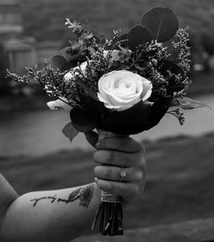 A couple shares a tender moment while holding a wedding bouquet outdoors.
prom 
riverside