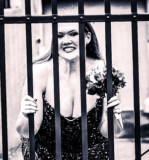 Artistic black and white portrait through metal bars with sparkly dress and flowers.
prom 
riverside