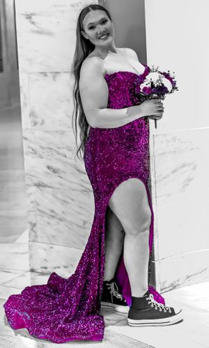 A person in a magenta sequin gown poses with a floral bouquet against a marble wall.
prom 
riverside