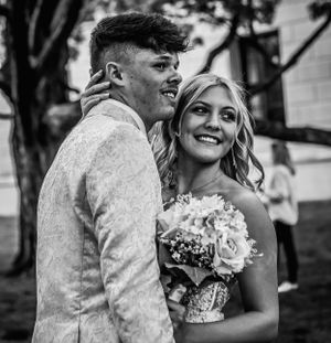 A black and white candid photo of a couple laughing together while holding a white bouquet.
prom 
riverside