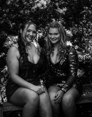 Black and white portrait of two people in formal dresses seated outdoors.
prom 
riverside