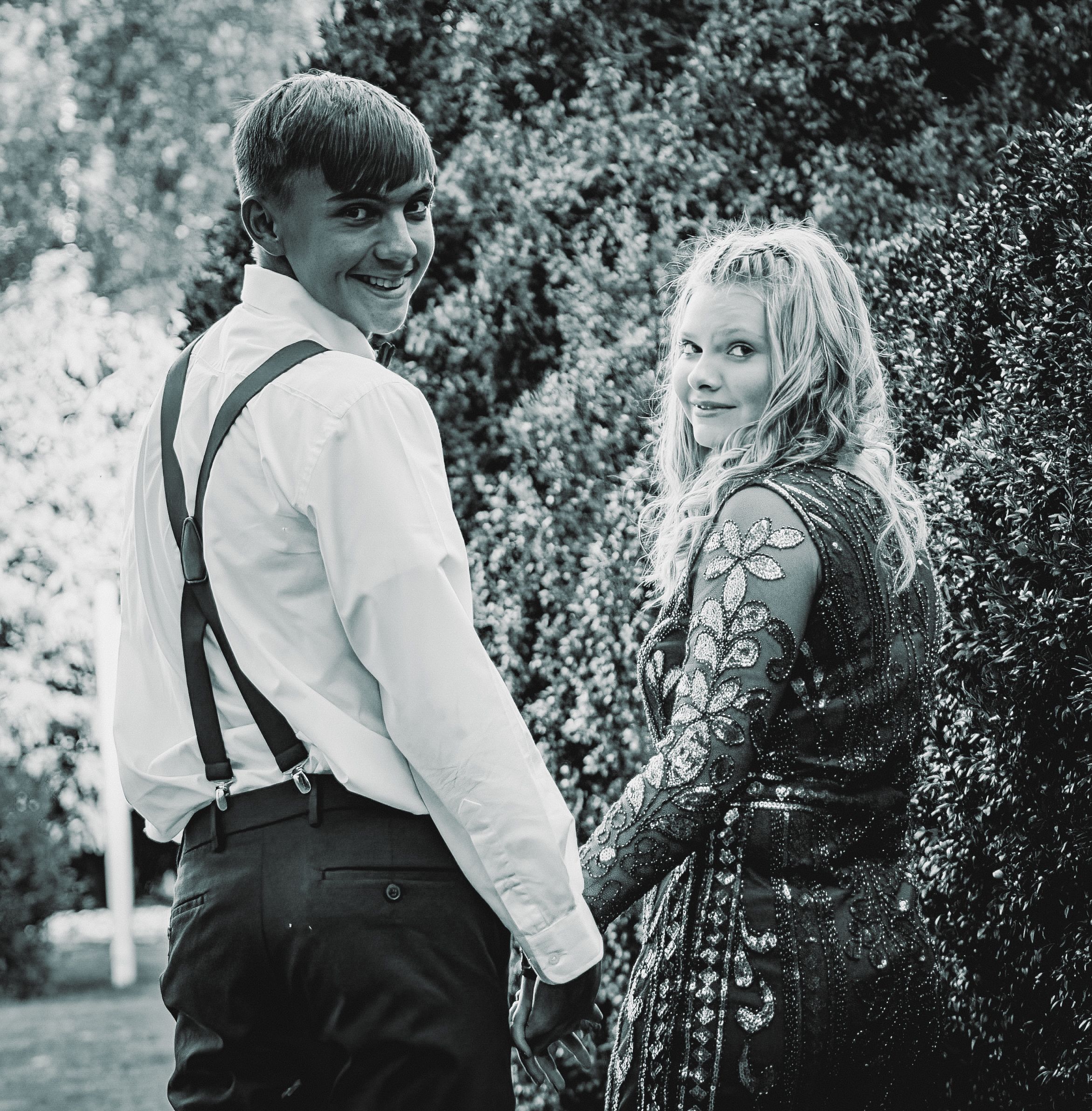 A vintage black and white photo of a couple in formal attire posing outdoors in a garden setting.
prom
riverside