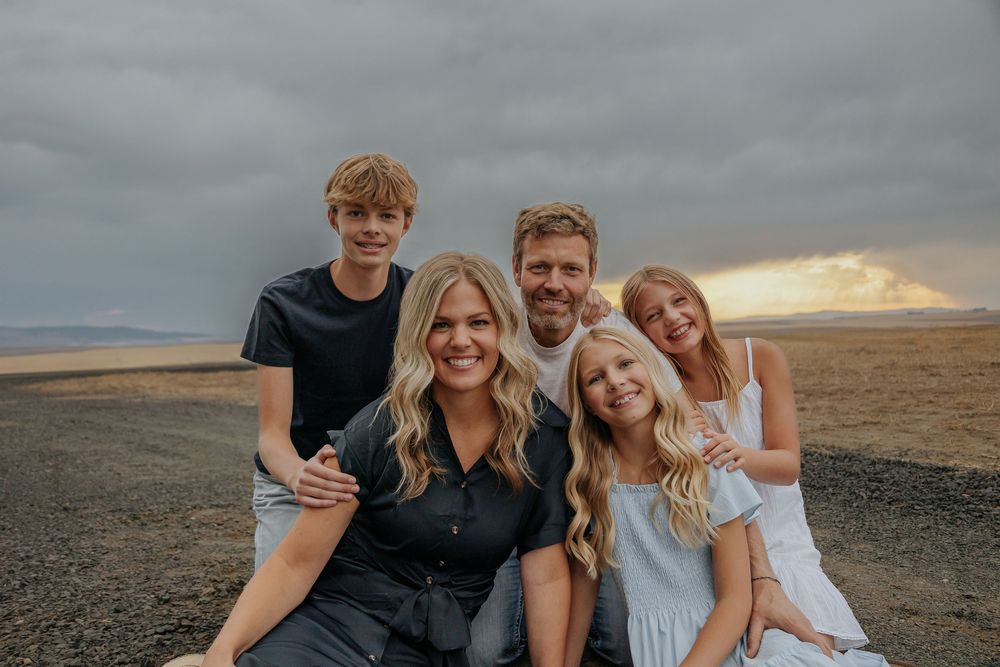 Casual family portrait session on a desert plain during golden hour.