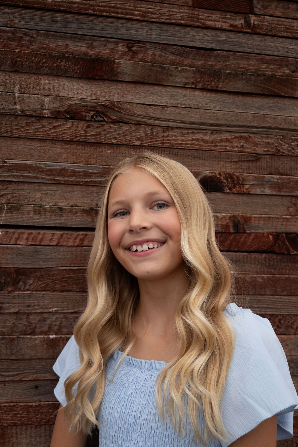 Close-up portrait with soft lighting against rustic wooden background.
