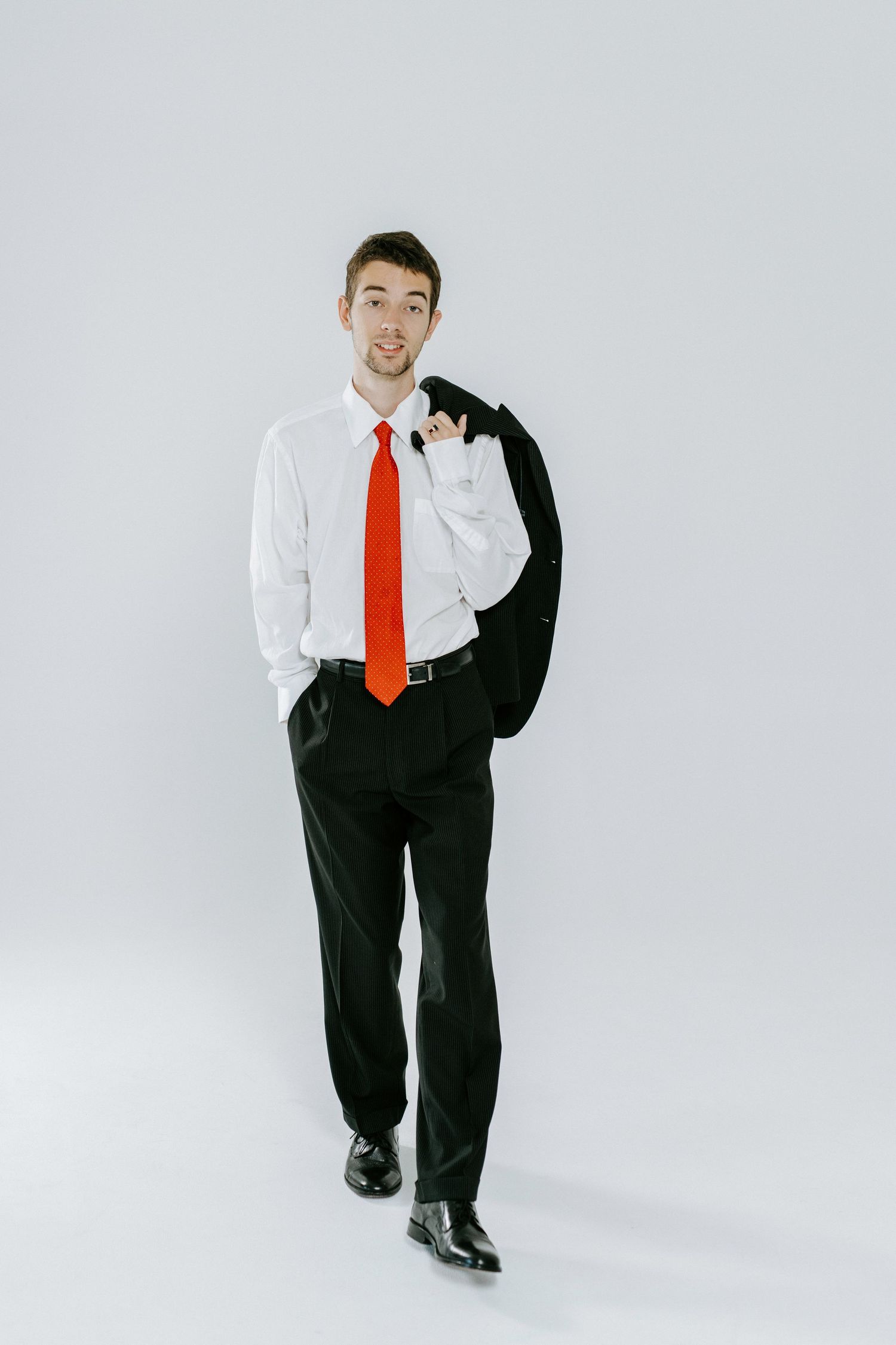 A person in business attire strikes different casual poses against a white backdrop in a four-image sequence.