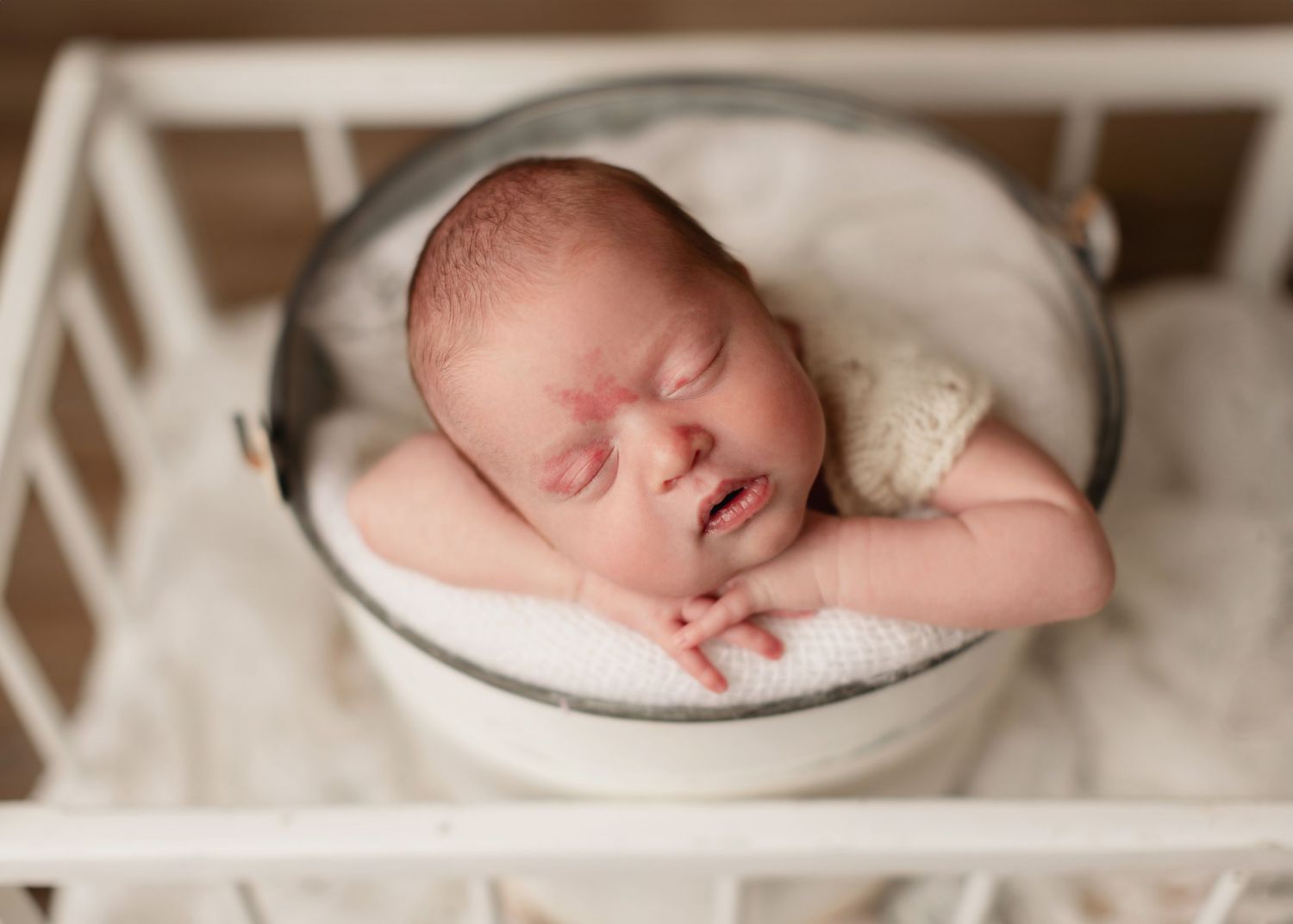 A series of peaceful newborn photography shots showing a sleeping baby wrapped in soft cream-colored blankets.