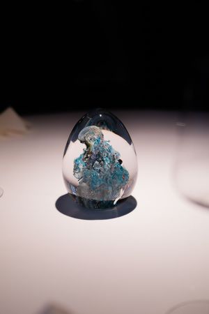 Crystal-like glass dome paperweight with blue mineral formations inside.