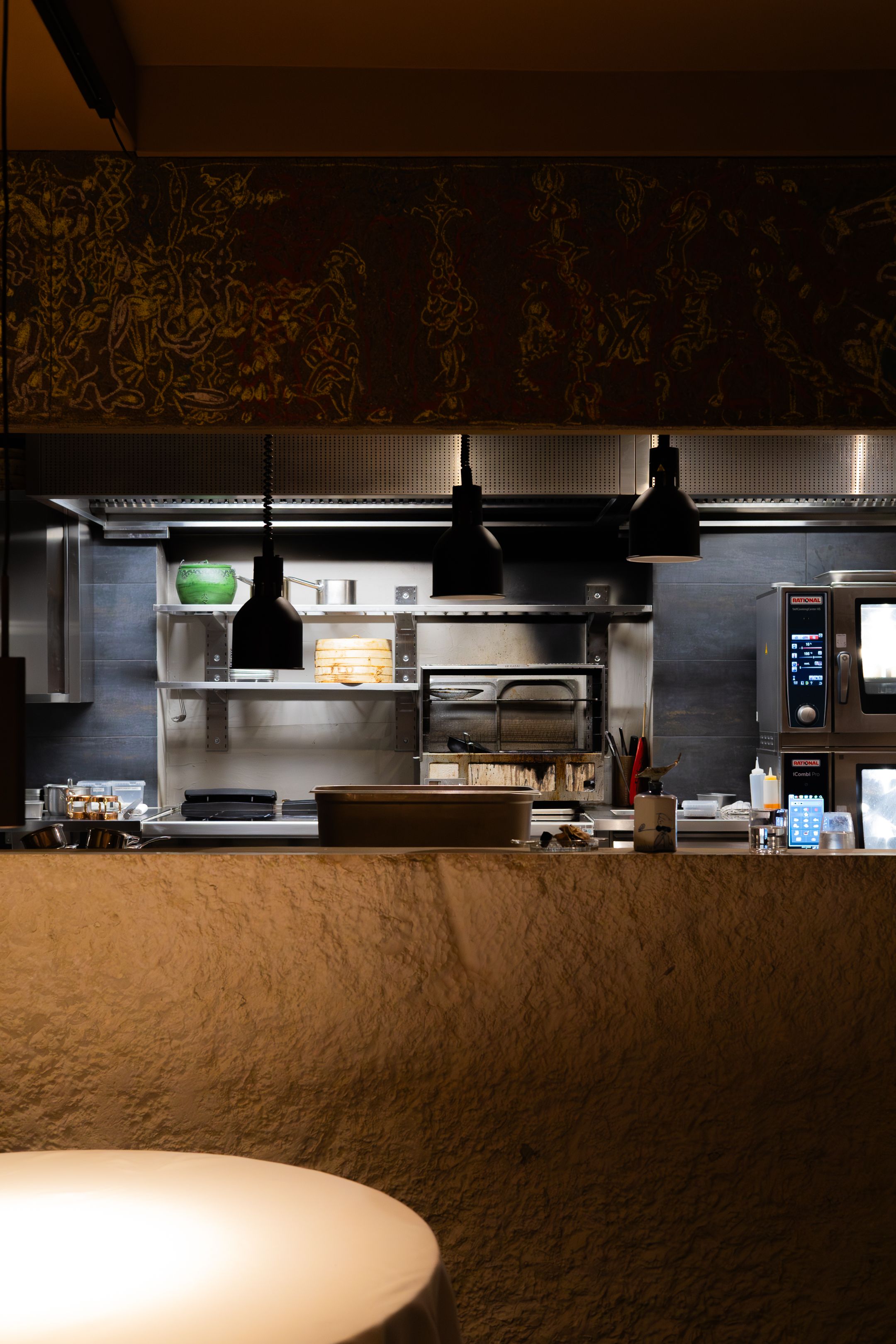 Modern restaurant interior with minimalist bar counter and warm lighting creating an intimate atmosphere.
