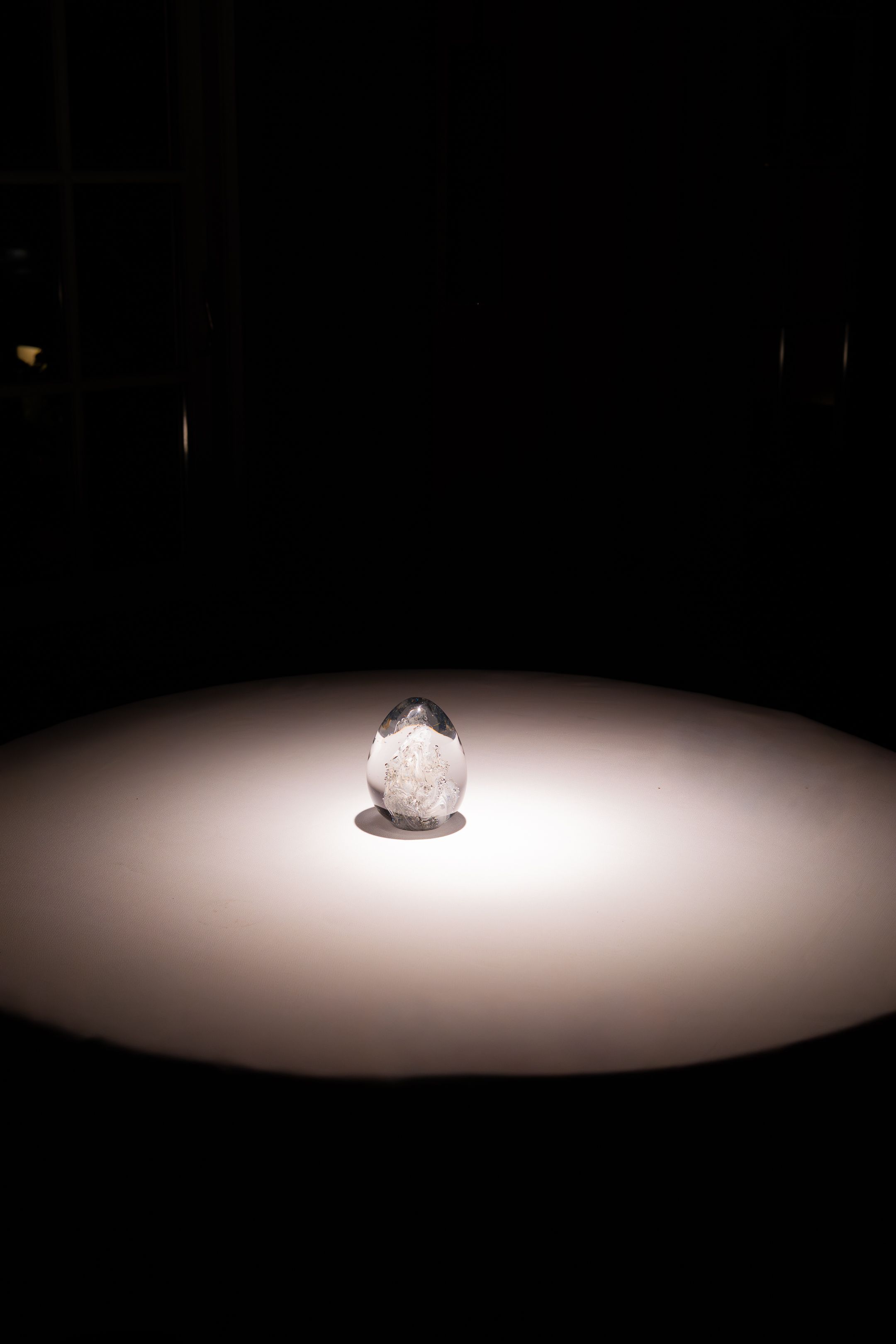 A sequence of spotlit objects on a dark stage shows progressively brighter illumination from left to right.
