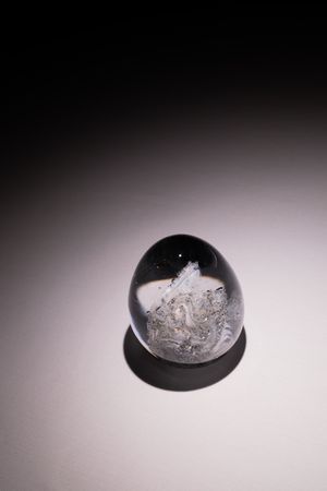 Time-lapse sequence showing ice melting in a black bowl against a gradient background.