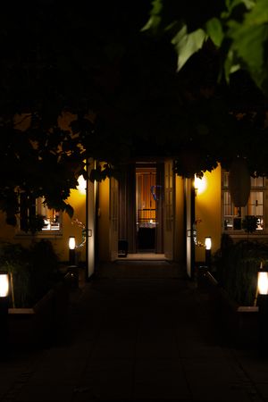 Illuminated building exterior at night with warm glowing lanterns and columns.