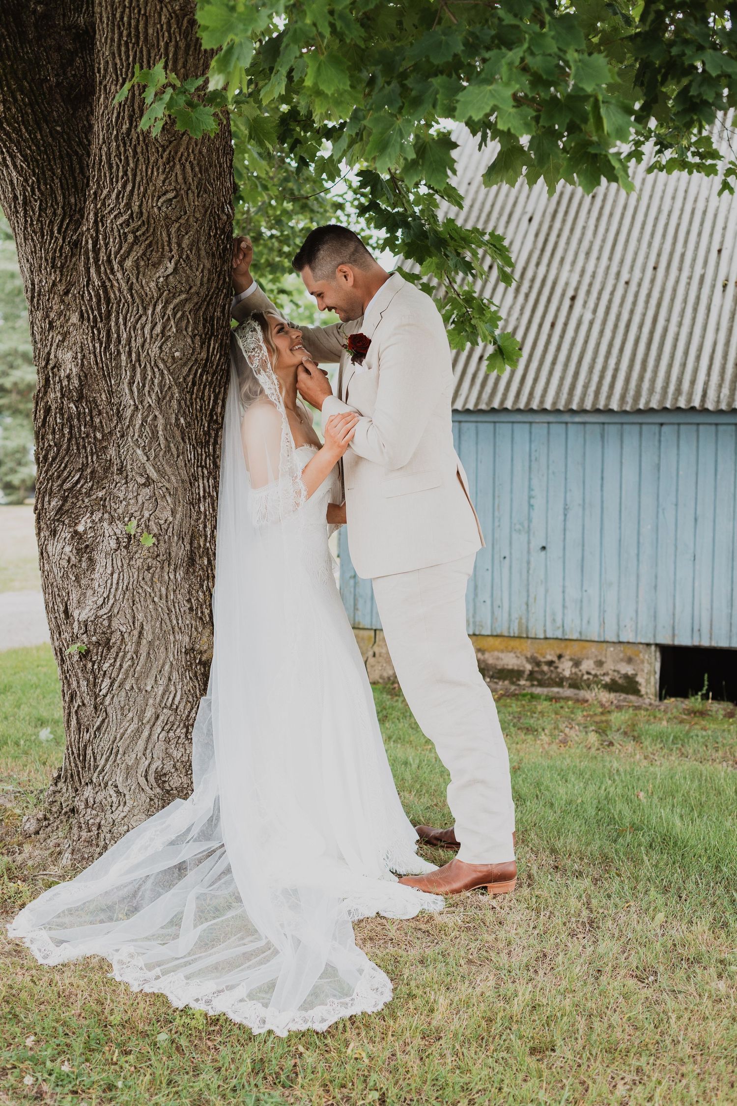 Romantic wedding couple shares intimate moments under a large tree in a series of candid outdoor photographs.