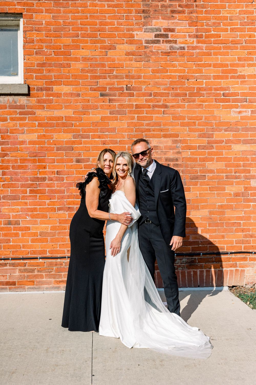 Bride and groom walking hand in hand near lakefront venue in Ontario
