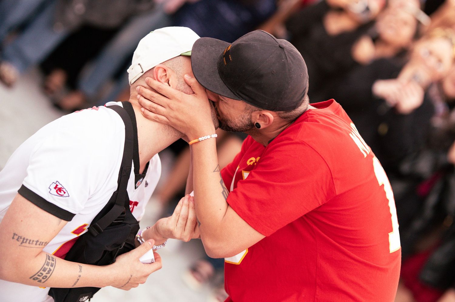 Excited sports fans in team jerseys celebrating at stadium event.