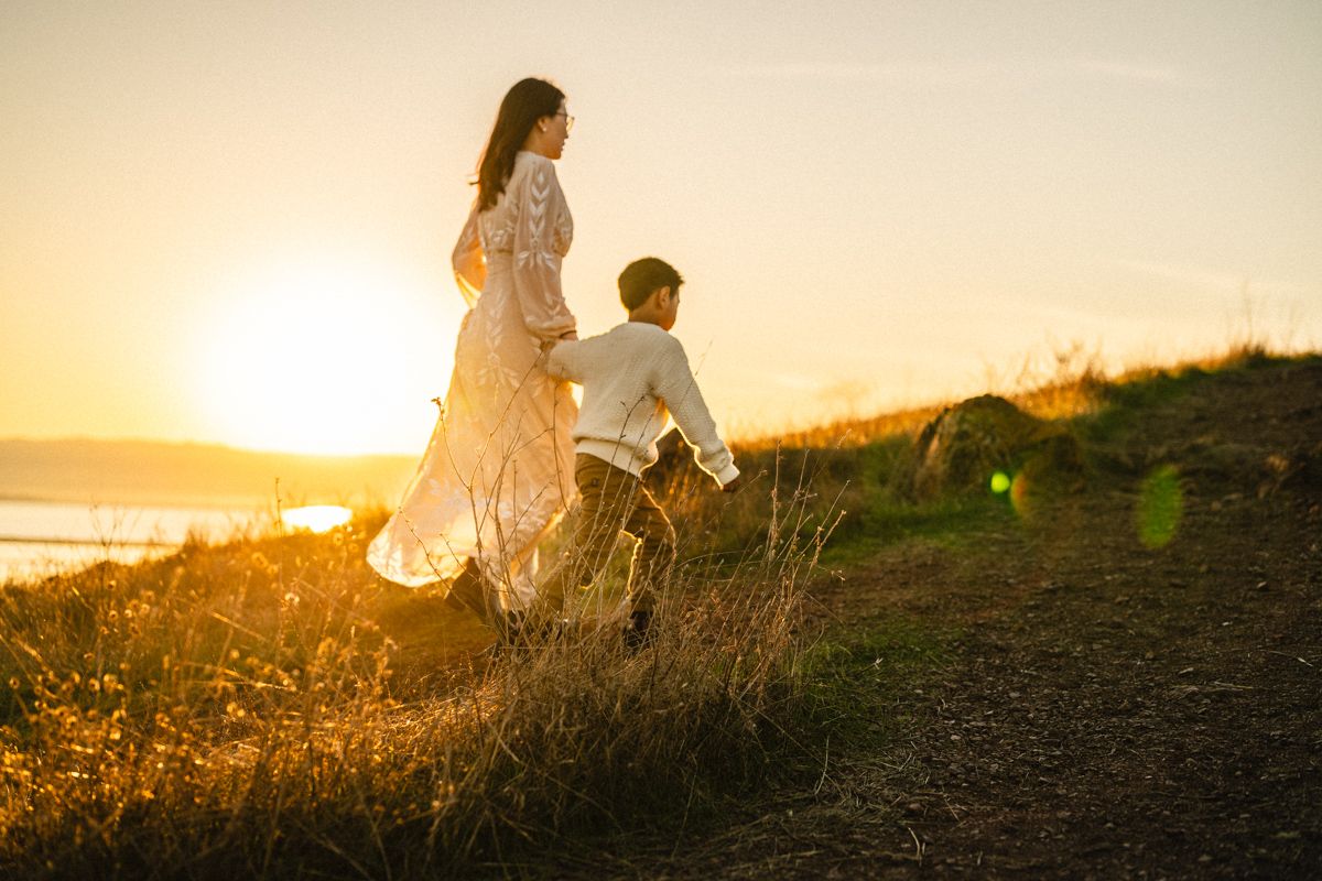 People share joyful moments together on a beach with the iconic Golden Gate Bridge visible in the background.