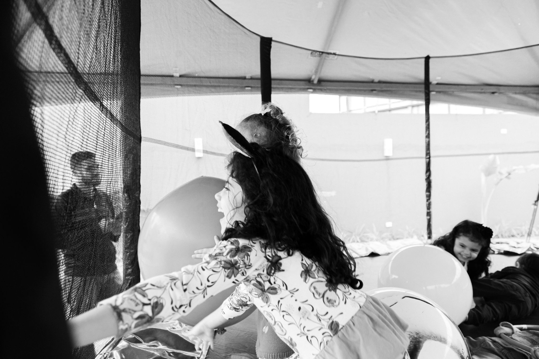 A series of candid black and white photos showing a casual indoor gathering or event.