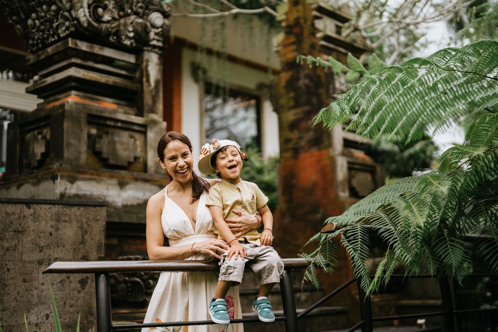 A heartwarming moment captured in a tropical garden setting with lush ferns.