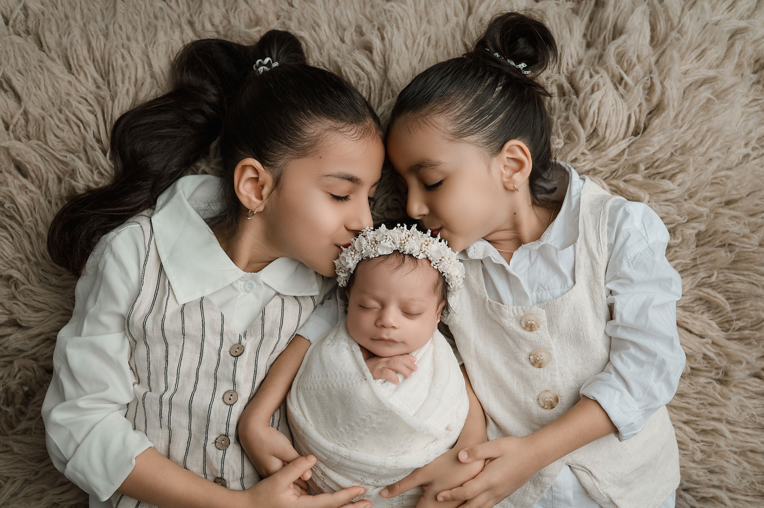 A heartwarming series of black and white photographs showing tender family moments and sibling affection on a plush carpet.