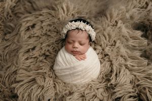 Seven connected images of a newborn photography session featuring a baby posed on beige flokati rug in various angles.